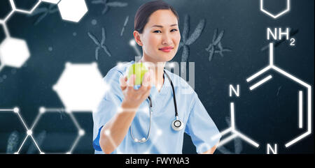 Immagine composita di sorridere chirurgo tenendo un Apple con il collega in ospedale Foto Stock