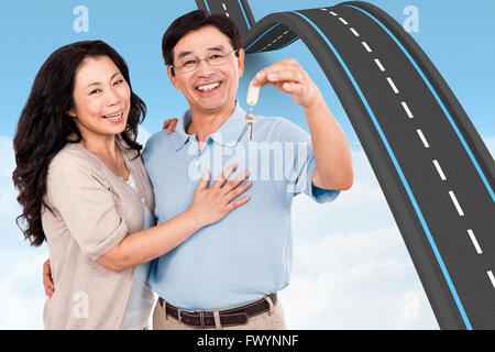 Immagine composita della coppia sorridente in possesso di un set di chiavi Foto Stock