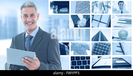 Immagine composita di happy businessman utilizzando tablet pc Foto Stock