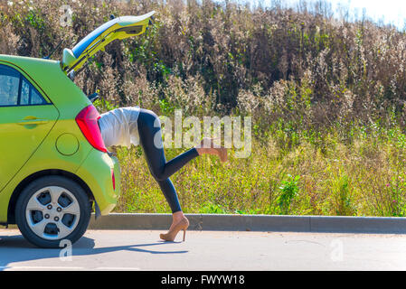 Slim ragazza in tacchi alti scarpe in linea è alla ricerca di qualcosa Foto Stock