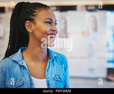 Business Nero donna sorridente mentre in piedi nel suo proprio negozio Foto Stock