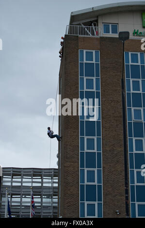 Kenilworth, Warwickshire, Regno Unito. 09Apr, 2016. Il procuratore generale Jeremy Wright QC MP abseiled verso il basso dalla parte superiore del Holiday Inn che si trova direttamente di fronte alla sua circoscrizione ufficio nel Warwickshire città di Kenilworth. Come locale MP ha detto che lui è stato vincendo la sua paura delle altezze per aiutare a raccogliere fondi per il Teenage Cancer Trust, egli spera di poter sollevare £1000 dalla sponsorizzazione dal caso in cui altre persone locali hanno preso parte anche nel pomeriggio di sabato 9 aprile 2016. Credito: Fraser Pithie/Alamy Live News Foto Stock