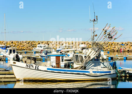 Simrishamn, Svezia - Aprile 1, 2016: bianca piccola barca da pesca ormeggiate al Marina in città. Altre barche e un molo di pietra in b Foto Stock