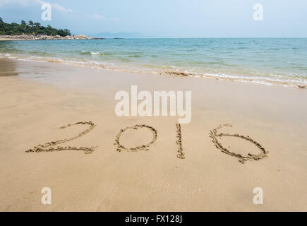 Anno 2016 scritto a mano sulla sabbia bianca di fronte al mare Foto Stock