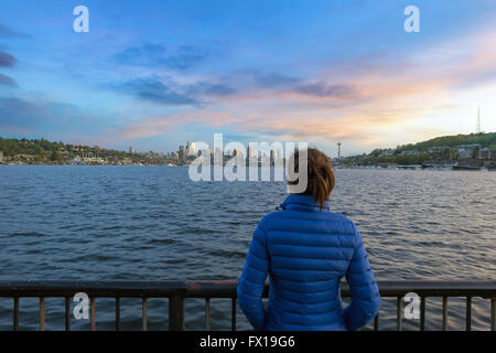 Donna guardando il tramonto su Seattle Washington Skyline lungo il Lago Union da lavori Gas Park Foto Stock