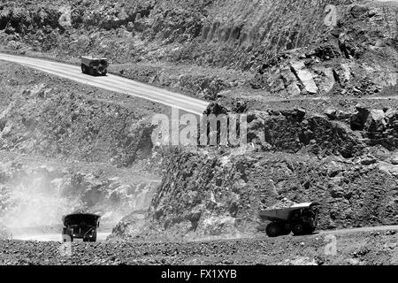 Caricate i carrelli industriali portano carichi pesanti del minerale di oro in salita dalla fossa aperta miniera d'oro in Kalgoorlie, Western Australia. Foto Stock