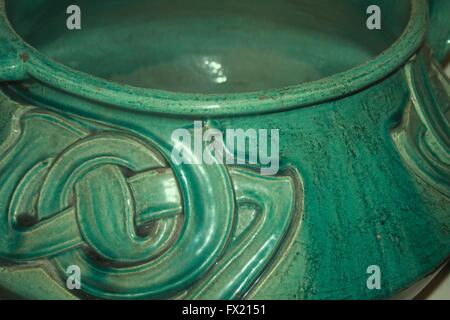 Close up di un verde pot vetrata con un arti e mestieri o arte nouveaux nodo celtico design Foto Stock
