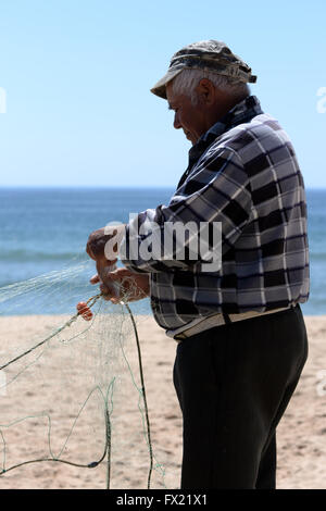 Pescatore sulla spiaggia di salpe, Algarve, PORTOGALLO Foto Stock