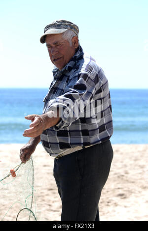 Pescatore sulla spiaggia di salpe, Algarve, PORTOGALLO Foto Stock