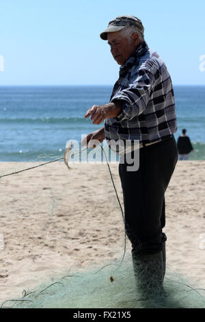 Pescatore sulla spiaggia di salpe, Algarve, PORTOGALLO Foto Stock