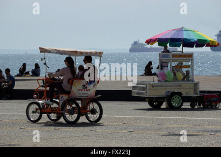 Turisti che si godono del panorama della città con un due-seduti in bicicletta in Tessalonica la zona fronte mare. La Grecia settentrionale. Foto Stock