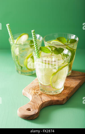 Cocktail mojito e ingredienti su sfondo verde Foto Stock