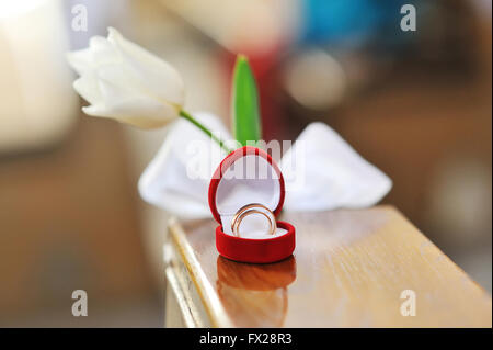 Gli anelli di nozze in un cuore scatola sagomata e fiore Foto Stock