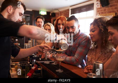 Barista dando Cocktail fare lezione agli amici in bar Foto Stock