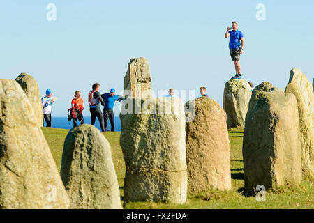 Kaseberga, Svezia - Aprile 1, 2016: turisti di visitare l'antico monumento megalitico di Ales pietre in Svezia. Le persone sono vestite Foto Stock