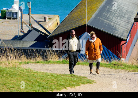 Kaseberga, Svezia - Aprile 1, 2016: l uomo e la donna a piedi in salita con una parte del porto in background. Si parla e felici. Essi h Foto Stock