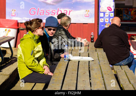 Kaseberga, Svezia - Aprile 1, 2016: giovane adulto giovane parlare al di fuori di un piccolo gelato diner nella marina. Vassoio vuoto sul tabl Foto Stock