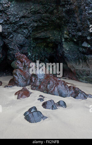 Rari affioramenti di roccia a serpentina sulla spiaggia di Kynance Cove sulla penisola di Lizard, Cornwall, Regno Unito Foto Stock