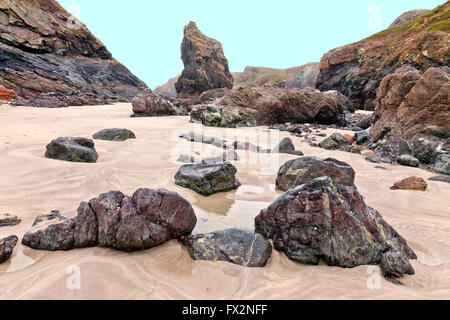 Rari affioramenti di roccia a serpentina sulla spiaggia di Kynance Cove sulla penisola di Lizard, Cornwall, Regno Unito Foto Stock