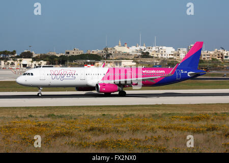 Basso costo viaggi aerei. Airbus A321 appartenente alla compagnia aerea bilancio Wizz Air con partenza dall aeroporto internazionale di Malta Foto Stock