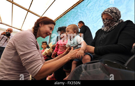 (160411) -- MAFRAQ, aprile, 11, 2016 (Xinhua) -- US attrice e il Fondo delle Nazioni Unite per la popolazione (UNFPA) ambasciatore di benevolenza Ashley Judd (L) tiene un bambino durante la sua visita al Zaatari Refugee Camp di Mafraq, Giordania, 10 aprile 2016. (Xinhua/Mohammad Abu Ghosh) Foto Stock