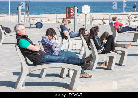 Barceloneta promenade con sedie in calcestruzzo e macchine ginniche e Spiaggia di Barceloneta a Barcellona, in Catalogna, Spagna. Foto Stock