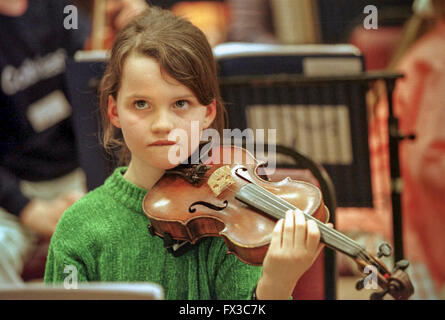 La giovane violinista in orchestra della scuola. Foto Stock