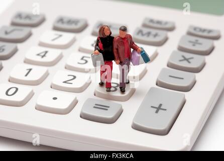 Statuetta in miniatura shoppers borse e zaini attraverso una calcolatrice key pad. Foto Stock