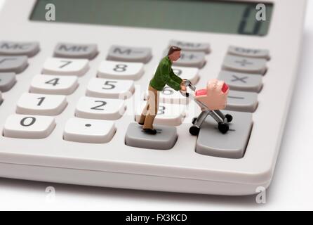 Un unico maschio statuetta in miniatura genitore spingendo una carrozzina su tasti della calcolatrice Foto Stock