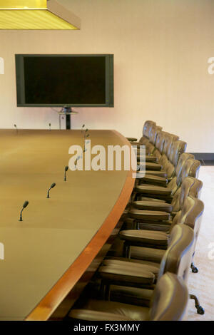 Posti vuoti ad un tavolo della sala consiliare. Foto Stock