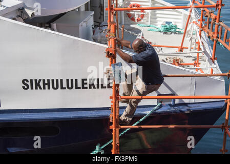 Il Sikhululekile un Robben Island traghetto passeggero si vede in Città del capo sottoposto a riparazioni allo scafo, lavoratore visto scendendo giù da un ponteggio. Foto Stock