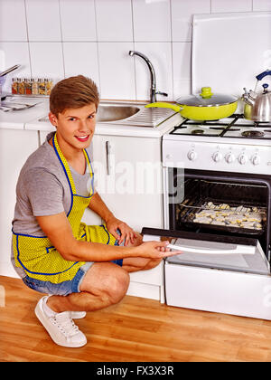 L'uomo prepara i biscotti nel forno. Foto Stock