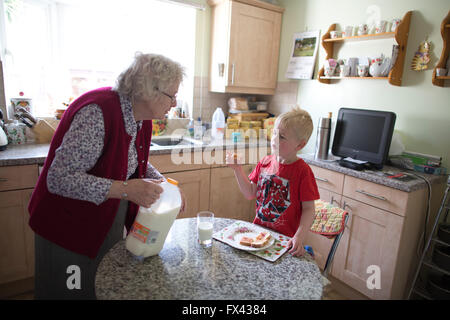 Titolare di pensione o di rendita anziani (età 80) cura dei suoi nipoti (di età compresa tra 2 e 5), a casa nel Dorset, England, Regno Unito Foto Stock