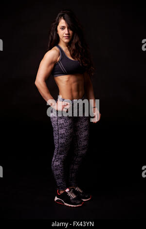 A piena lunghezza Ritratto di muscolare dai capelli scuri giovane donna Foto Stock