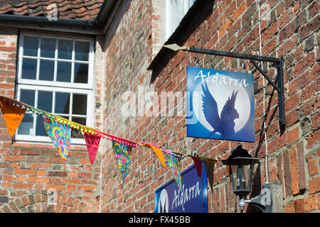 Shop segno anteriore e bunting nella strada alta. Glastonbury, Somerset, Inghilterra Foto Stock