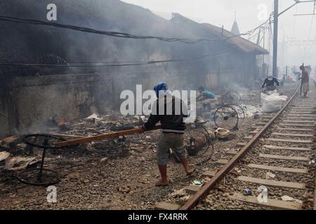 Jakarta, Indonesia. 26 gen, 2016. Un uomo tenta di spegnere un incendio in una delle baraccopoli accanto ai binari ferroviari in Kampung Bandan. Il fuoco ha distrutto circa 100 abitazioni in legno, costruito lungo una trafficata linea ferroviaria. © Garry Andrew Lotulung/Pacific Press/Alamy Live News Foto Stock