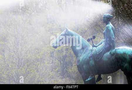 Una lunga esposizione di colpo di 'Amazon a cavallo' statua come l'acqua di un prato irroratore pellicce off presso Tiergarten di Berlino, Germania, 11 aprile 2016. La statua è stata realizzata dallo scultore Luigi Tuaillon. Foto: PAOLO ZINKEN/dpa Foto Stock