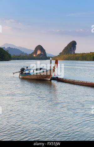 Vista al tramonto del fiume di Krabi con barca long-tail e calcare scogliere carsiche, Krabi town, Thailandia Foto Stock