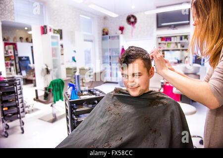 Irriconoscibile parrucchiere il taglio di capelli della sua giovane client. Foto Stock