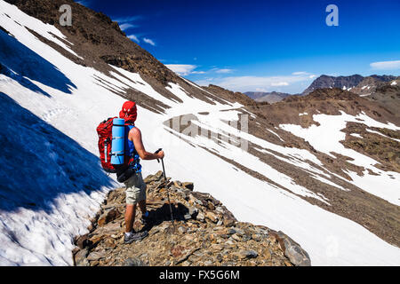 Trekker rivolta verso il Tajo de los Machos sul suo modo di montare Mulhacen, il picco più alto della penisola iberica. Sierra Nevada, Gr Foto Stock