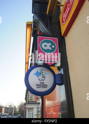 Lotteria nazionale e Payzone segni sul lato esterno di un locale convenience store Foto Stock