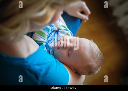 La madre mantiene un po' di sonno bambino nelle braccia Foto Stock