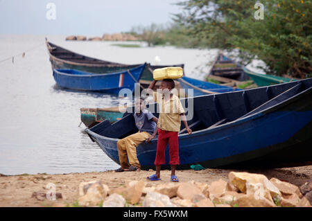 Bambini raccolta di acqua in bidoni di dal lago Vittoria in Uganda, Africa Foto Stock