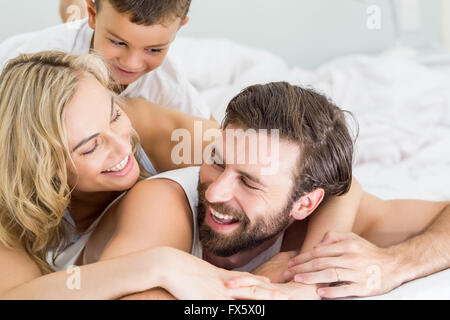 Genitori e figlio giacente sul letto e divertirsi Foto Stock