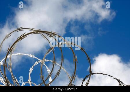 Filo di rasoio contro un cielo blu con nuvole Foto Stock