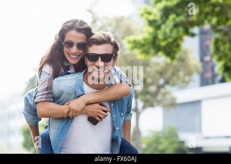 L uomo dando piggyback per donna Foto Stock