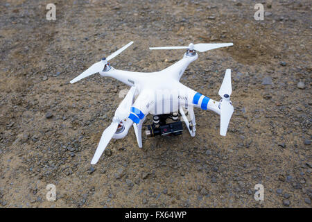 Quad copter drone di stile sul terreno con una telecamera collegata pronto per il volo e film. Foto Stock