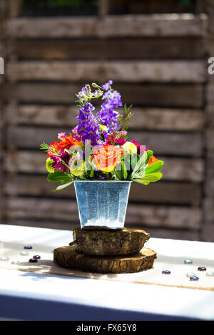 Nozze centritavola diy su tavole in occasione di un ricevimento di arancione e verde fiori. Foto Stock