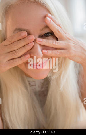 La donna caucasica spiata da dietro gli occhi Foto Stock