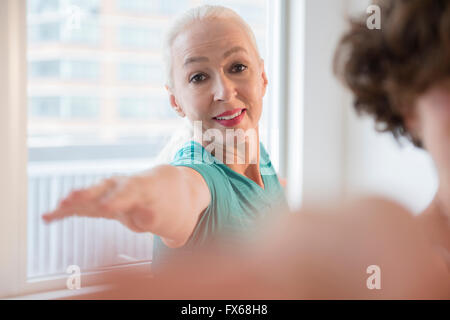 Le donne a praticare yoga in classe Foto Stock